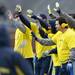 Former Michigan football players on the maize look to high five a player as he comes off the field during the annual alumni flag football game before spring practice at Michigan Stadium on Saturday, April 13, 2013. Melanie Maxwell I AnnArbor.com